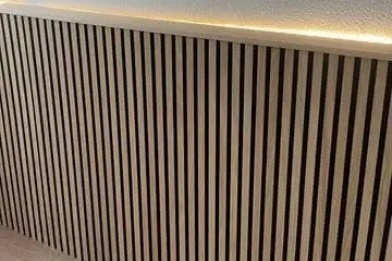 Pared con revestimiento de madera y luces LED incorporadas para un diseño elegante.