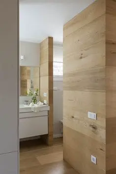 Revestimiento de madera natural en paredes de baño moderno y acogedor.