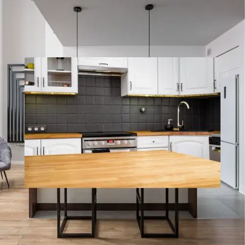 Cocina contemporánea con muebles blancos, encimera e isla de madera, e iluminación colgante sobre una superficie práctica y elegante
