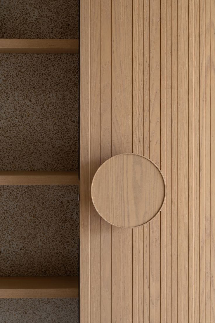 Detalle de puerta con revestimiento de madera enchapada y textura ranurada moderna.