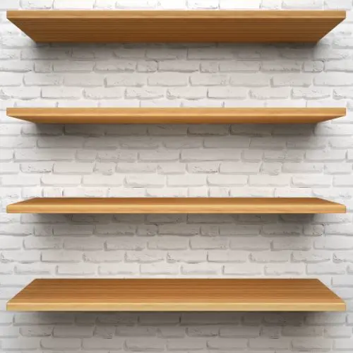 Tres estantes flotantes de madera clara sobre una pared de ladrillos blancos, listos para exhibir objetos decorativos o vajilla.