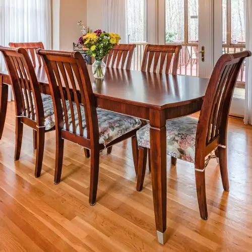 Mesa de comedor de madera con sillas a juego, brindando un espacio acogedor y elegante para reuniones familiares