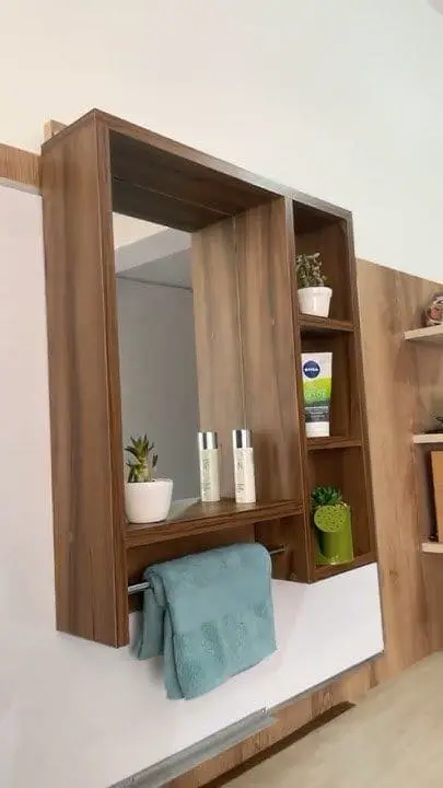 Botiquín de madera con espejo y puerta corrediza, combinando almacenamiento oculto y diseño minimalista en el baño