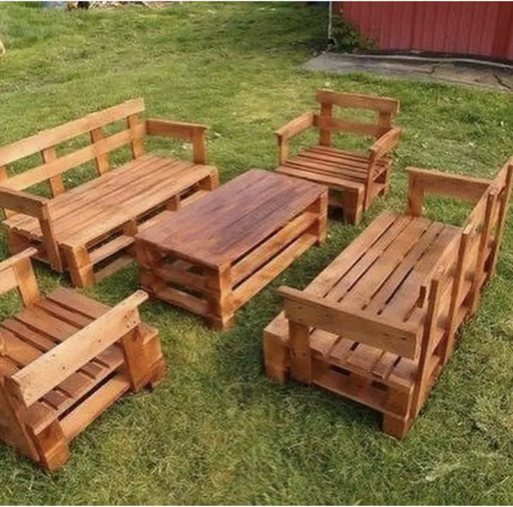 Conjunto de muebles de madera estilo rústico hechos con pallets, compuesto por sofás, sillones y una mesa central para jardines.