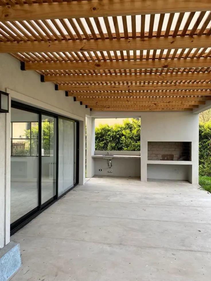 Pérgola de madera con diseño moderno instalada en una terraza amplia, ideal para proporcionar sombra y estilo al exterior.