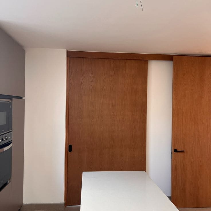 Puertas corredizas con revestimiento de madera en una cocina contemporánea