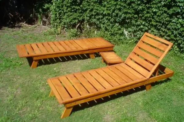 Dos reposeras de madera resistentes y funcionales ubicadas en un jardín, ideales para descansar al aire libre.