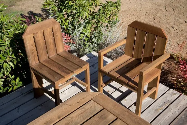 Dos sillas de madera para exteriores con diseño robusto y clásico, ubicadas en una terraza al aire libre